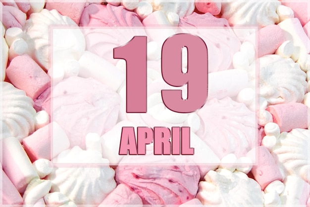 Kalenderdatum op de achtergrond van witte en roze marshmallows 19 april is de tweeëntwintigste dag van de maand