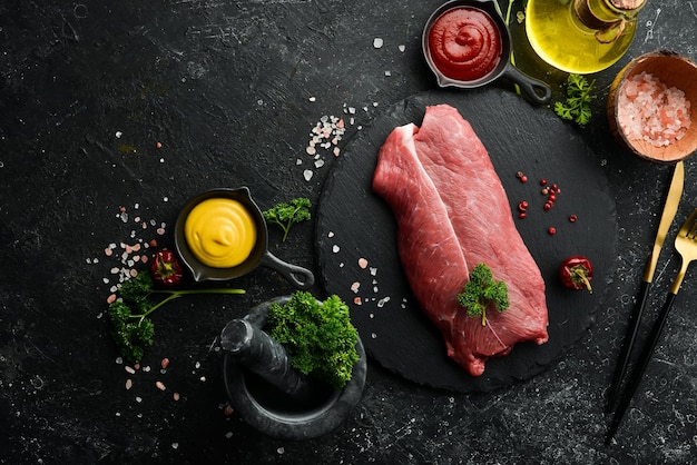 Kalfslapje biologisch rauw vlees filet biefstuk op zwarte leisteen achtergrond Bovenaanzicht Rauw vlees