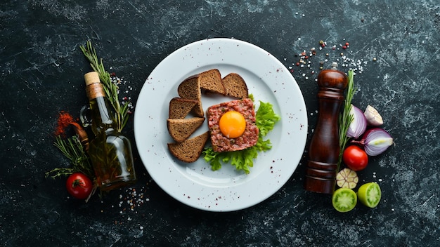 Kalfstartaar met eigeel en zwart brood Bovenaanzicht Vrije ruimte voor uw tekst