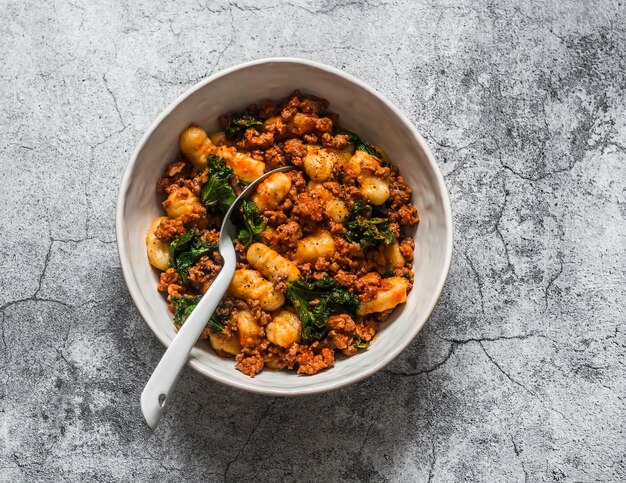 Kalkoenkool kool tomatensaus hash en aardappel gnocchi heerlijke lunch in mediterrane stijl op een grijze achtergrond bovenaanzicht