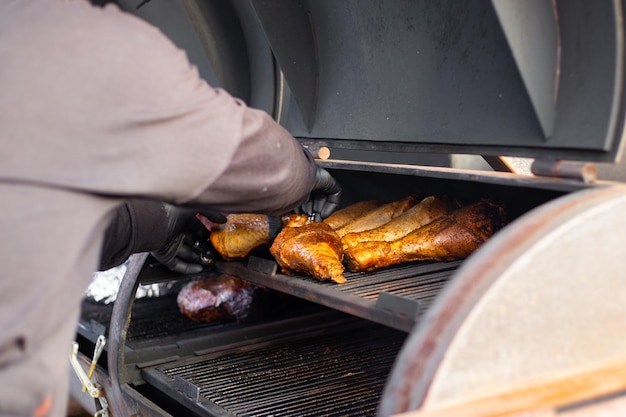 Foto kalkoenpootjes worden op een professionele grill gebakken. het proces van het bereiden van vlees voor een picknick.