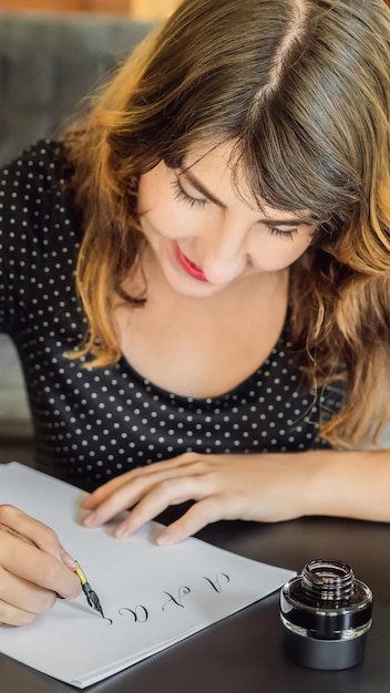 Kalligraaf jonge vrouw schrijft zin op wit papier bijbel zin over liefde inscriptie sier