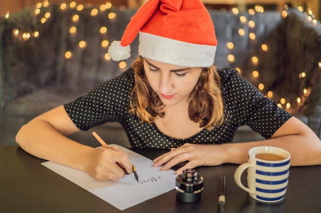 Kalligraaf jonge vrouw schrijft zin op wit papier