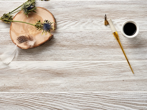 Kalligrafiepen en inkt op een houten witte tafel. Bovenaanzicht.