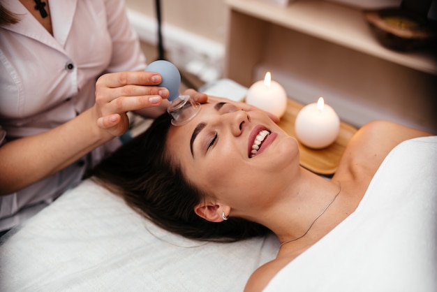 Kalm meisje met spa gezichtsmassage in luxe schoonheidssalon.