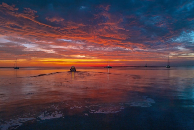 Kalme zee met zonsonderganghemel en zon door de wolken over oceaan en hemelachtergrondzeegezicht