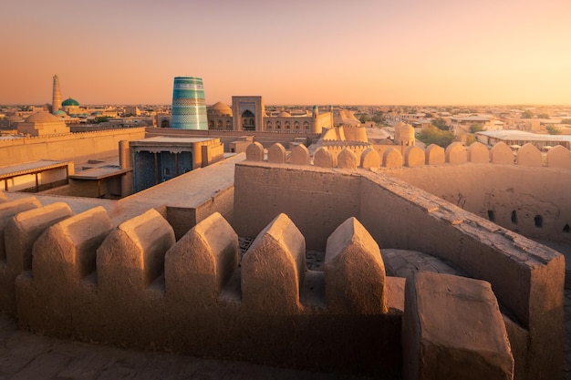 Photo kalta minor madrasah and ancient wall in old city from kunya ark citadel at sunset khiva uzbekistan