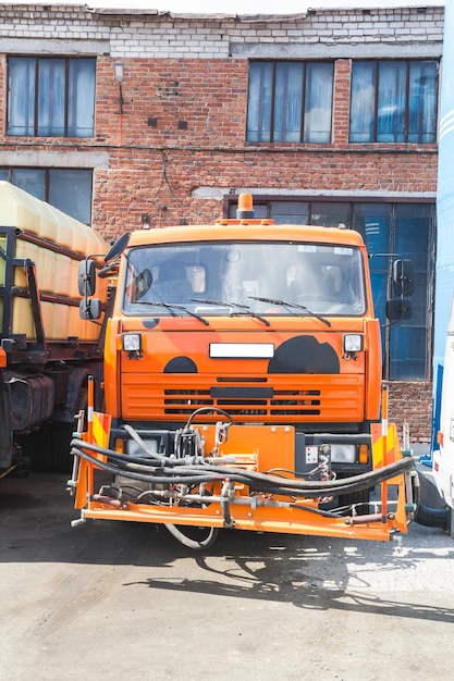 Kamaz-vrachtwagen staat op de parkeerplaats op de achtergrond van een bakstenen gebouw
