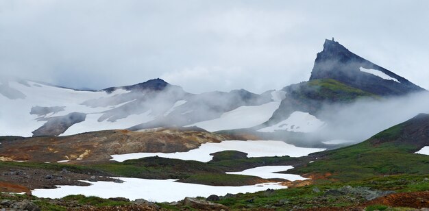 Kamchatka. foto van bergen en sneeuw. groen gras, geisers