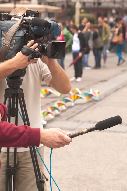 Foto kameraman met verslaggever die een interview geeft op straat