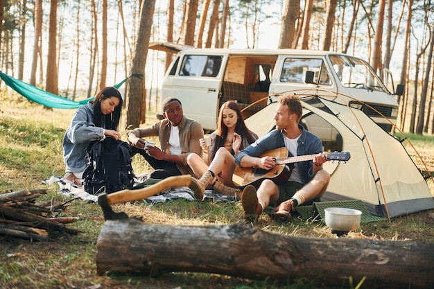 Kamp en auto Groep jongeren reist overdag samen in het bos