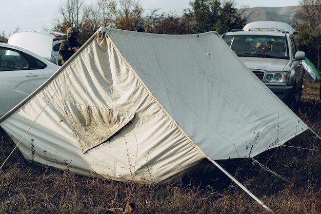 Kampeertent en twee auto's op een weiland