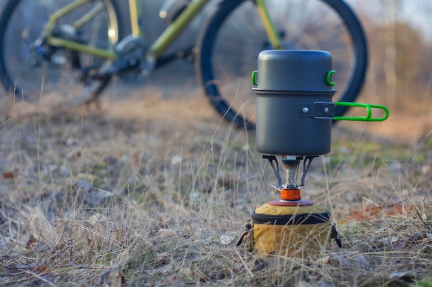 Kamperen in de open lucht op de achtergrond van een fiets en een bos Toeristische gasbrander met pannen om te koken