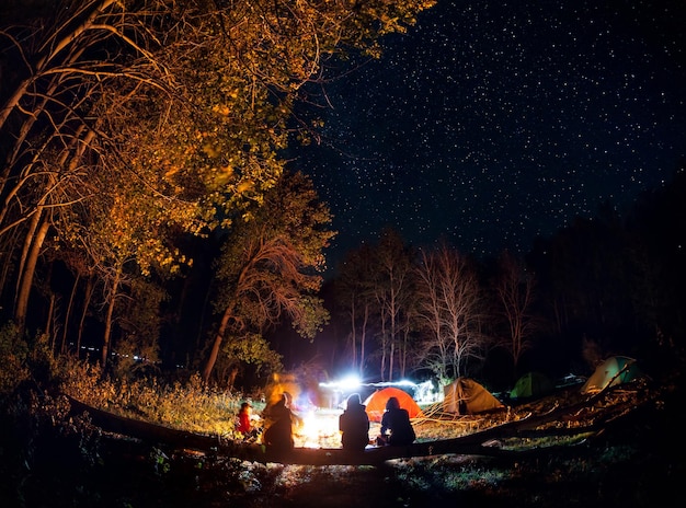 Kamperen in het bos met kampvuur 's nachts