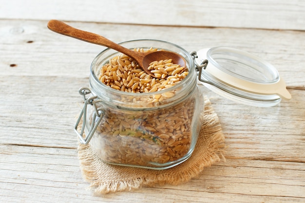 Kamut grain in a glass on a wooden  background