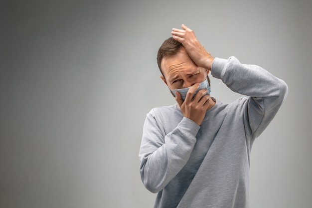 Kan niet ademen. Blanke man die het adembeschermingsmasker draagt tegen luchtvervuiling en stofdeeltjes overschrijden de veiligheidslimieten. Gezondheidszorg, milieu, ecologie concept. Allergie, hoofdpijn.