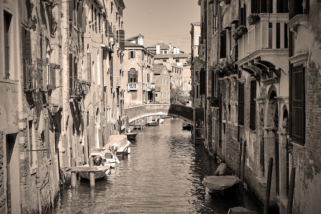 Kanaal in Venetië met boten, Italië. Zwart-wit sepia getinte fotografie, Venetiaanse weergave