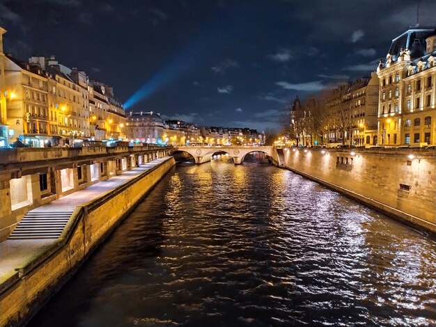 Foto kanaal te midden van verlichte stad tegen de nachtelijke hemel