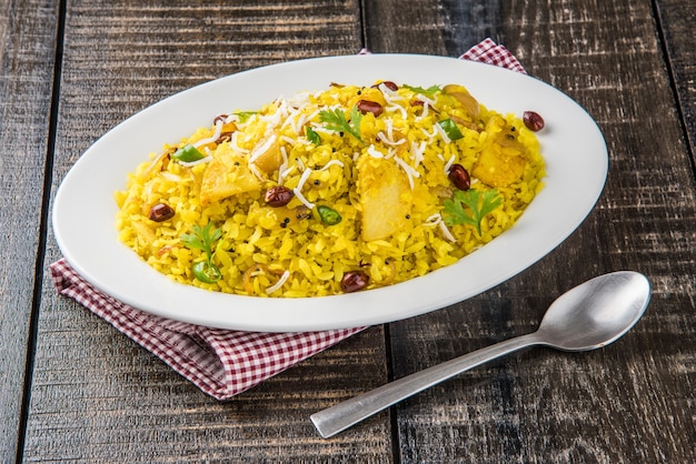 Kande Pohay 또는 Aloo Poha는 일반적으로 뜨거운 차와 함께 제공되는 납작한 쌀을 사용하여 만든 인기 있는 인도식 아침 식사 레시피입니다. 위에 그릇에 제공됩니다. 선택적 초점