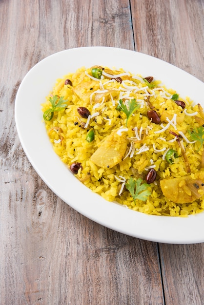 Kande Pohay 또는 Aloo Poha는 일반적으로 뜨거운 차와 함께 제공되는 납작한 쌀을 사용하여 만든 인기 있는 인도식 아침 식사 레시피입니다. 위에 그릇에 제공됩니다. 선택적 초점