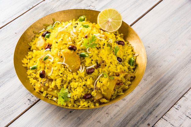Kande Pohay OF Aloo Poha is een populair Indiaas ontbijtrecept gemaakt met platte rijst, meestal geserveerd met hete thee. Geserveerd in een kom erover. Selectieve focus