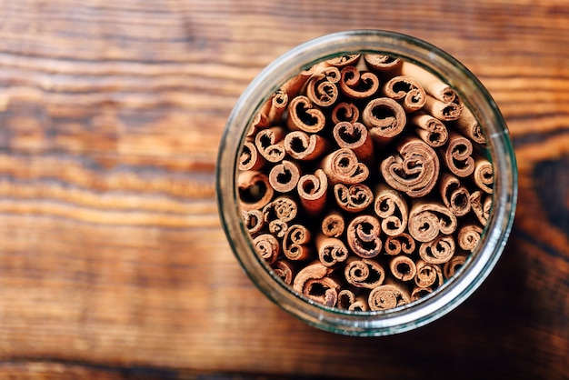 Kaneelstokjes in pot op houten tafel. Van bovenaf bekijken en ruimte kopiëren.