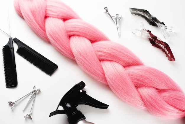 Kanekalon roze haar op wit oppervlak met kammen en haaraccessoires