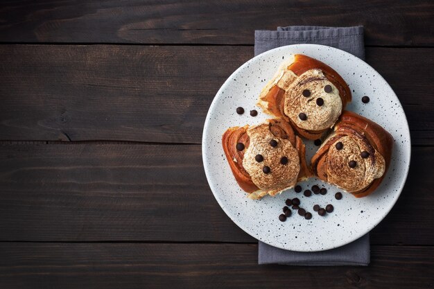 Kanelbulle Cinnamon buns with buttercream on a rustic wooden table. Homemade fresh pastries. top view, copy space.