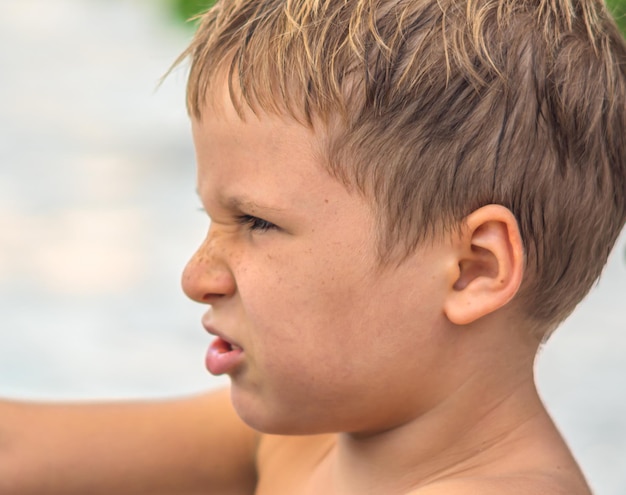 Kant portret ondeugende schattige blonde jongen jongen sproeten gezicht boze stemming ontevreden gerimpelde neus gezichtsuitdrukking gebaren Jeugd relatie gedrag onderwijs mentaal probleem ouderschap