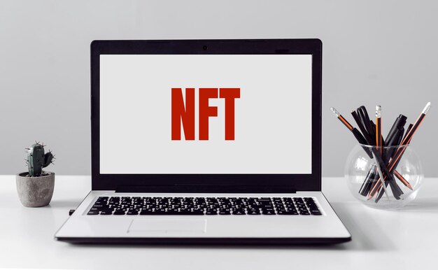 Kantoor tafel en laptop met tekst NFT Niet-fungible token