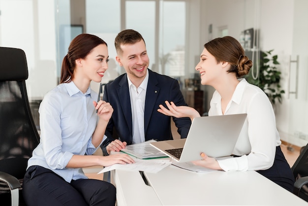 kantoormedewerkers die samen een project doen en lachen om hun pauze in een modern bedrijfsgebouw