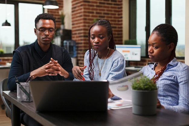 Kantoorpersoneel van de boekhoudafdeling die financiële gegevensgrafieken op werklaptop analyseert. Bedrijfscollega's die op het computerscherm een presentatie volgen over toekomstige marketingstrategie.