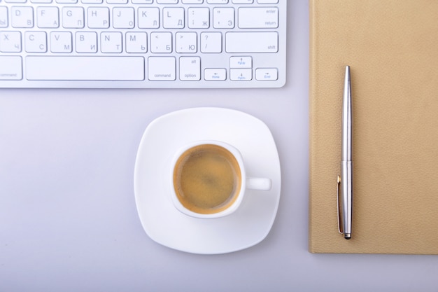 Kantoortafel met notebook, toetsenbord, kopje koffie, tablet pc. kopieer ruimte.