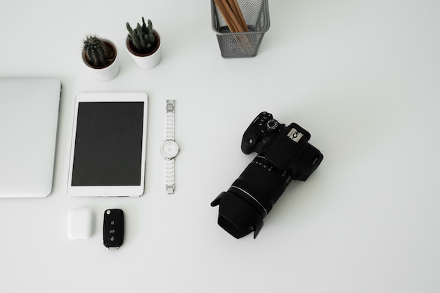 kantoortafel waarop laptop, koffie, tablet, camera en andere items