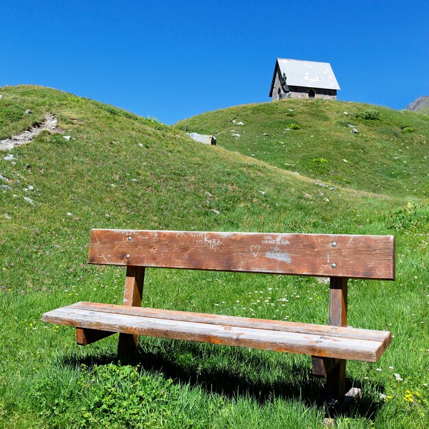 Kapel en bank in alpiene berg in de zomer