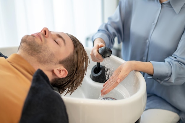 Kapper die haar wast aan haar mannelijke cliënt