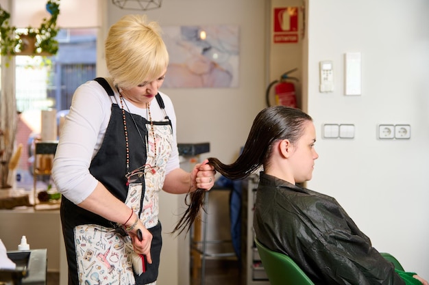 Kapper droogt en stylet het haar met een föhn in de schoonheidssalon