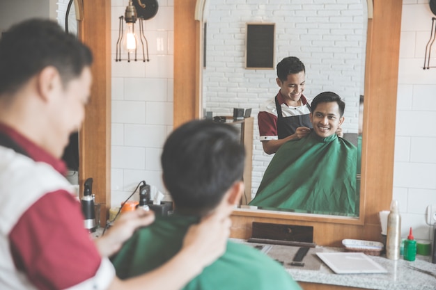 Kapper kapsel maken voor een aantrekkelijke man in de kapsalon