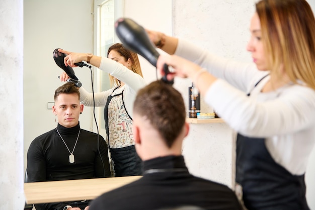 Kapper knippen haar en stylen van een klant in de kapperszaak