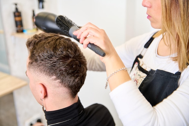 Kapper knippen haar en stylen van een klant in de kapperszaak