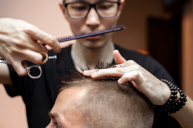 Kapper knipt het haar van een klant in een kapperszaak