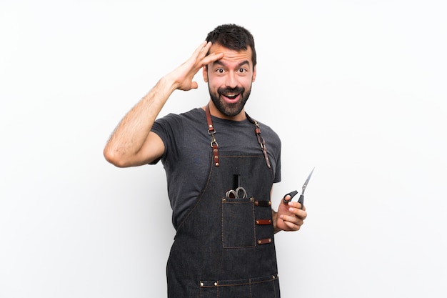 Kapper man in een schort heeft net iets gerealiseerd en is van plan de oplossing