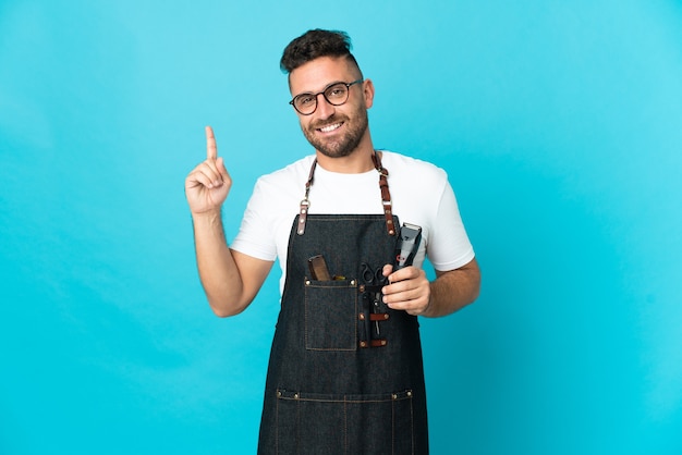 Kapper man in een schort tonen en een vinger opheffen als teken van het beste