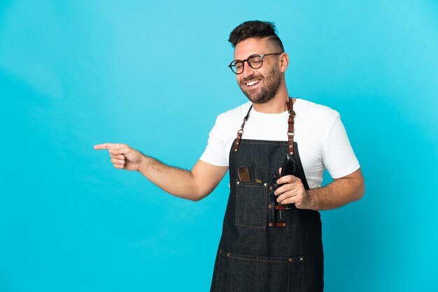 Kapper man in een schort wijzende vinger naar de zijkant en presenteert een product