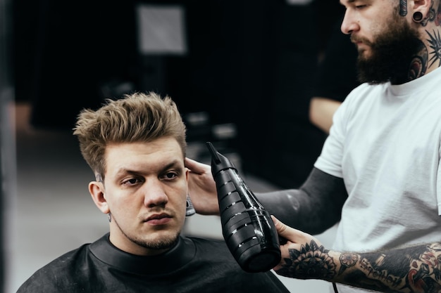 Kapper mannelijk haar drogen in kapsalon