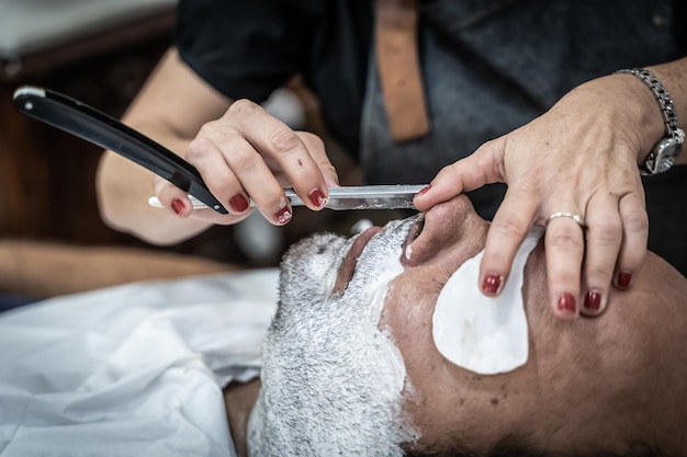 Kapper scheert een ontspannen klant in een kapperszaak