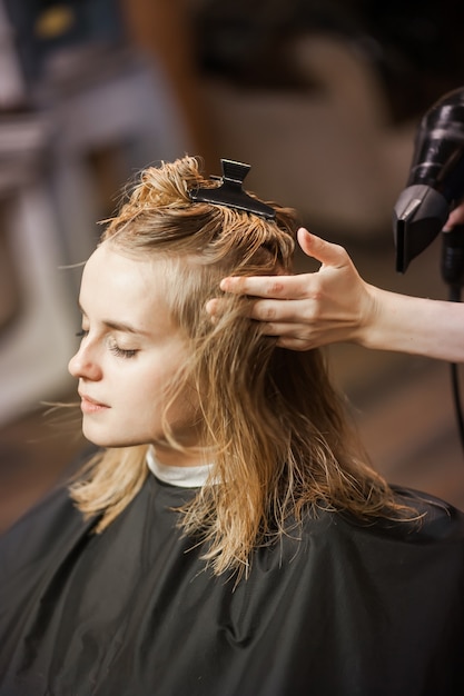 Kapper-stylist droogt nat haar met een föhn