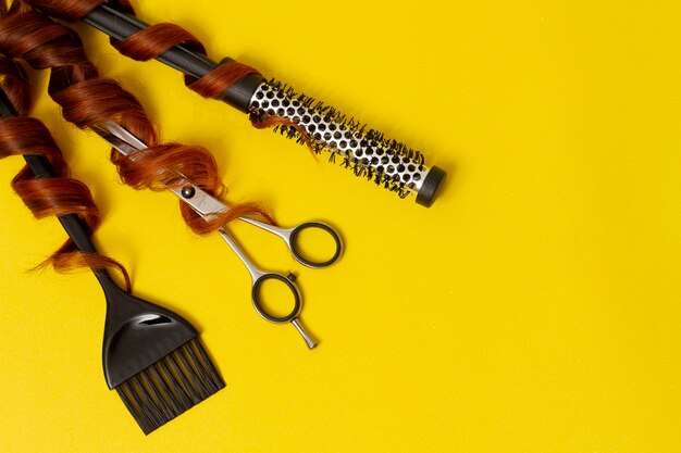 kapper stylist tools, schaar, kam, borstel, op een gele achtergrond, horizontaal