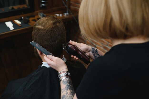 Kapper vrouw man haar knippen bij de Barbershop. Vrouw die als kapper werkt. Klein bedrijfsconcept.