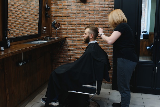 Kapper vrouw man haar knippen bij de Barbershop.